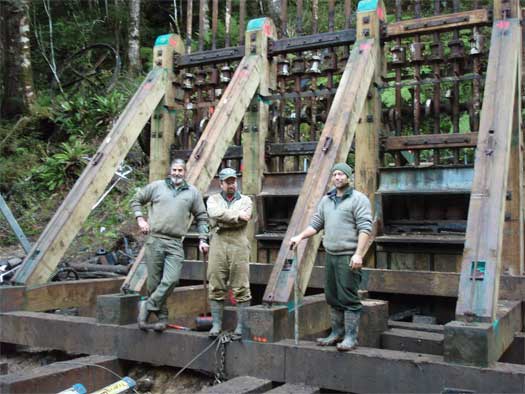 Three people standing at the battery. 