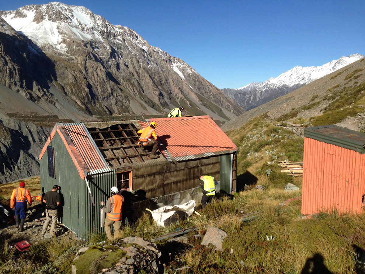 Workers preparing historic Hooker Hut for removal. 