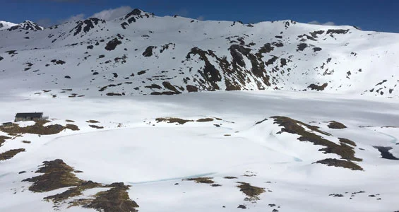 Lake Angelus under snow with hut in background. 