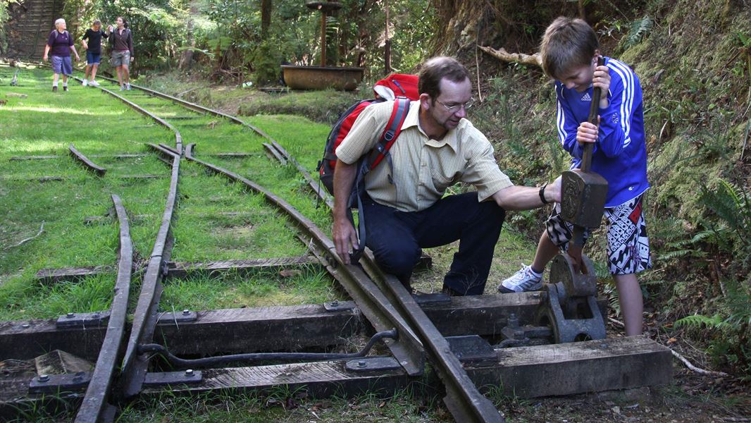 Man and boy exploring historic relics on track.