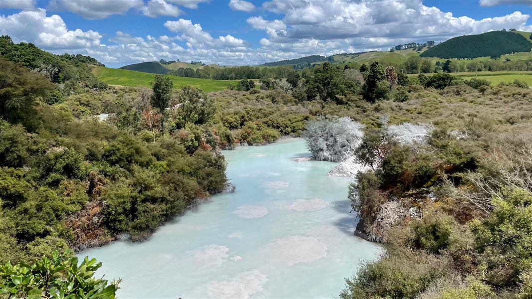 Light turquoise opaque thermal pool with bubbling mud.   