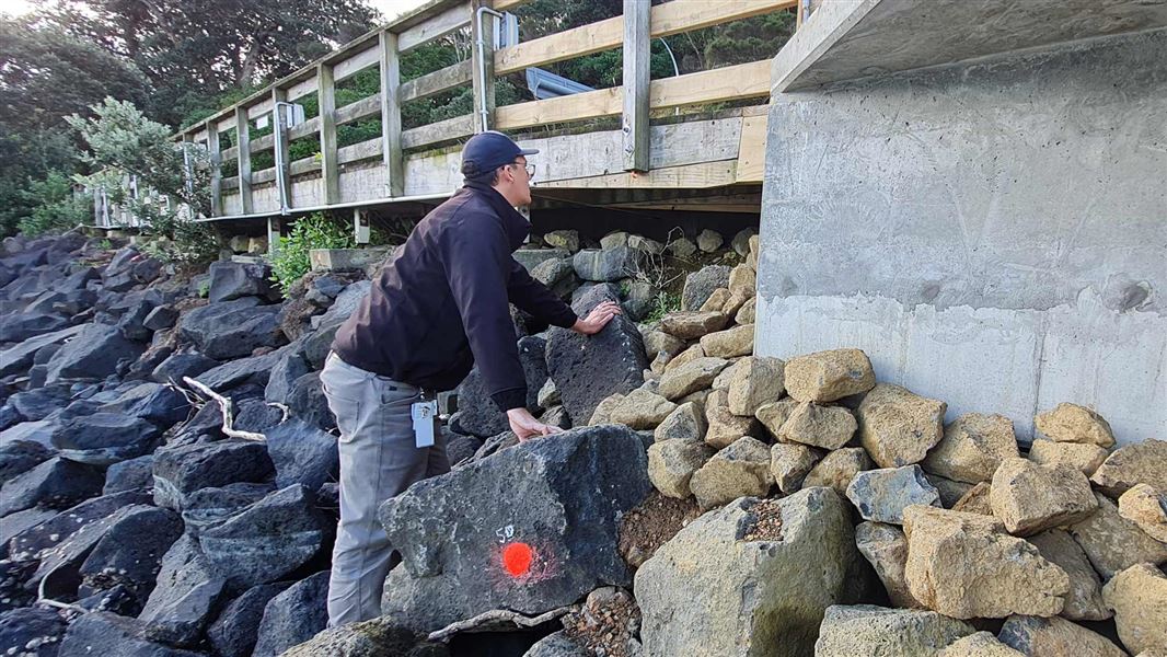 DOC staff member checking rock placement on Kennedy Point Marina.