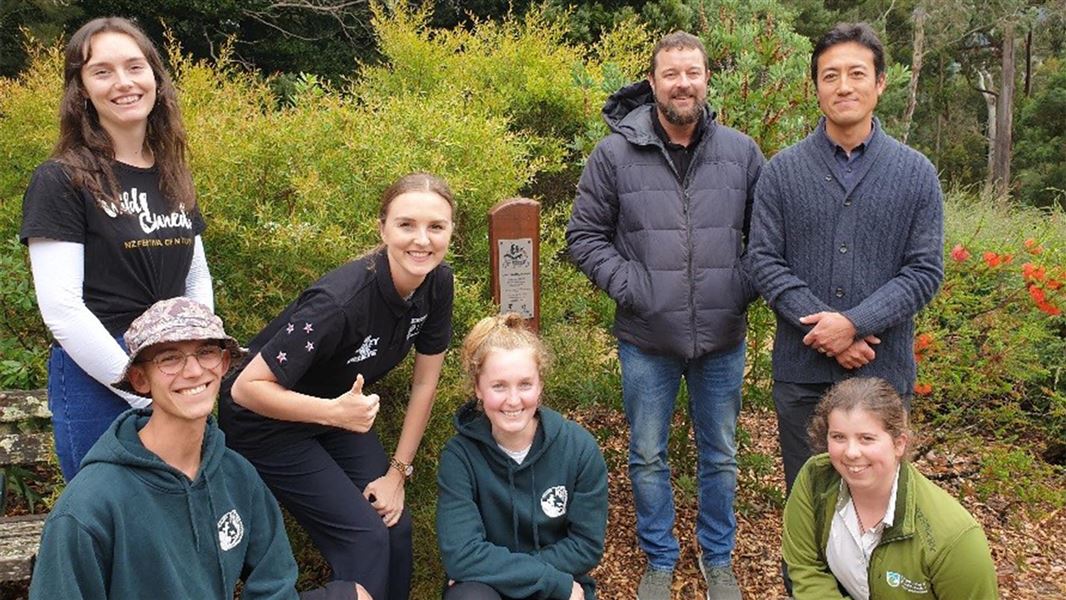 5 people pose next to a Toyota Kiwi Guardians totem pole.