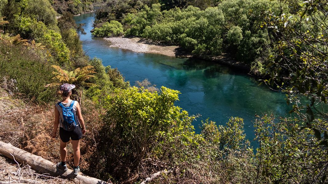 Person standing near river.