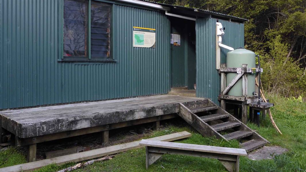 A corrugated iron hut in a forest.