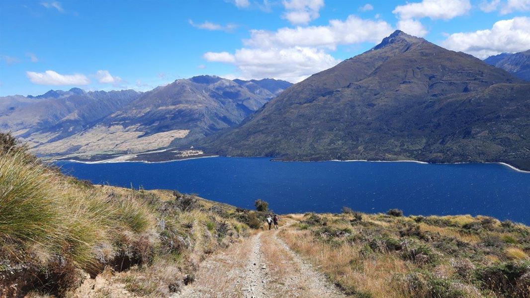 Walking track with lake and hills in back.