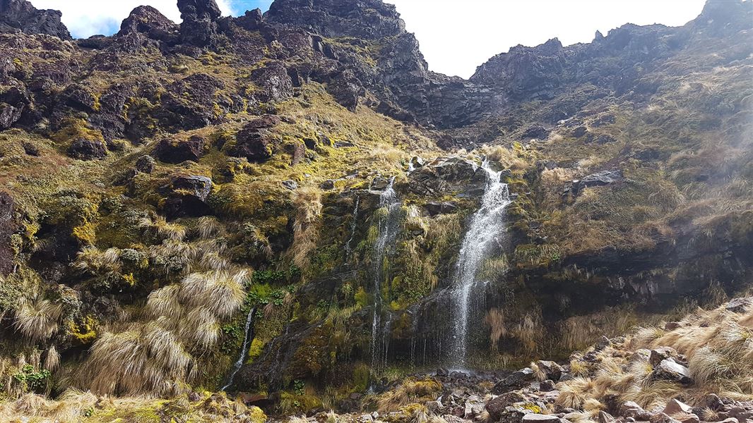 Waterfall on rocky hill.