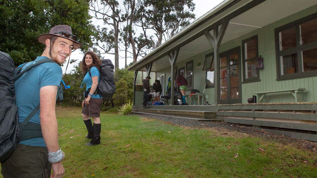 Trampers with packs outside Port William Hut.