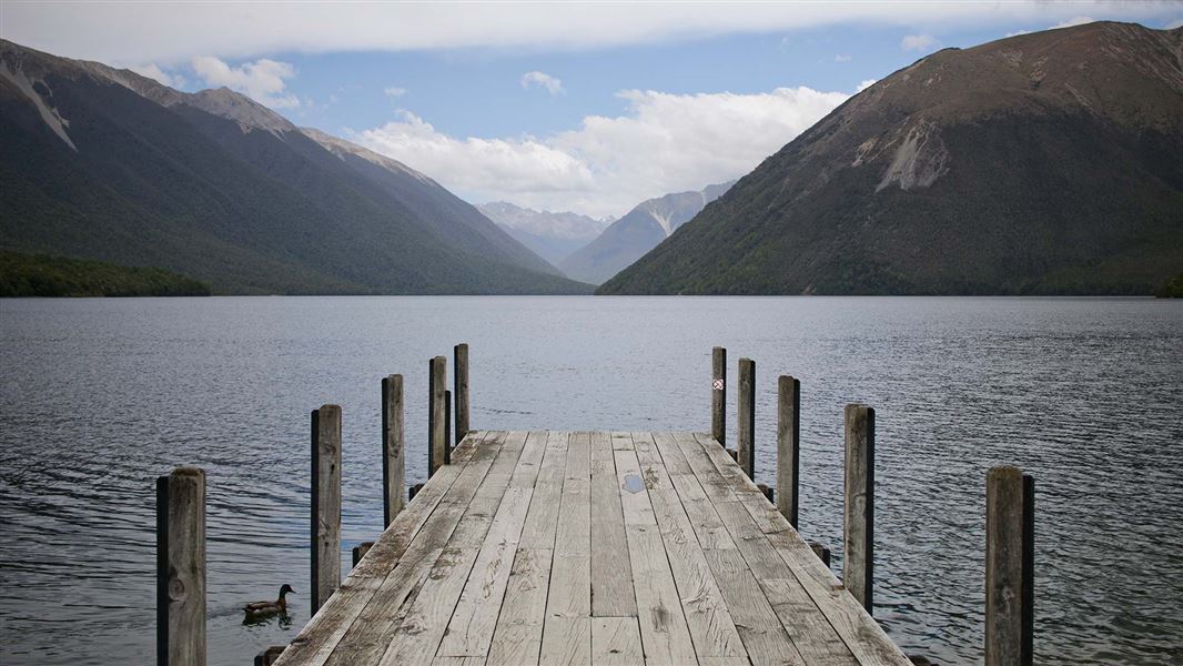 A jetty extending into a clear lake.