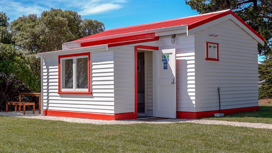 A newly painted white cottage with bright red accents.