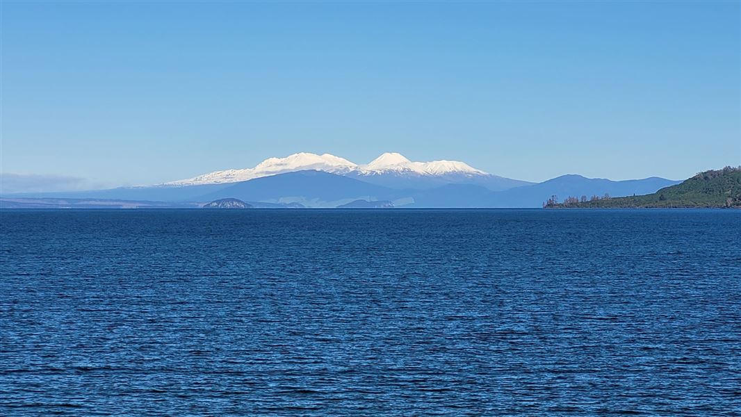 A blue lake with mountains in the far distance.