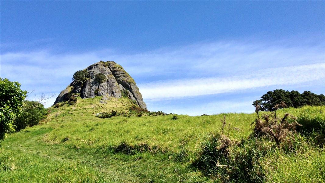 Large rock at the top of a grassy track.