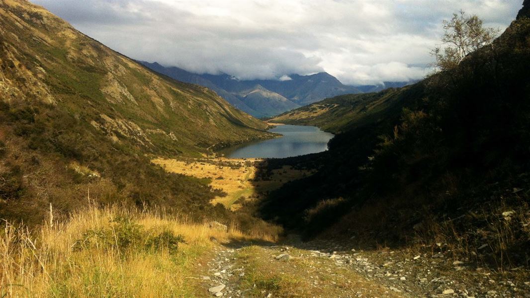 Looking down at a lake in a mountain valley from a ridge.