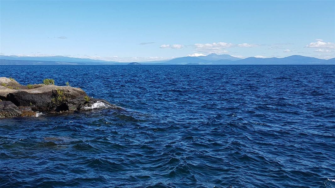 View out across the lake to the mountains of the Tongariro National Park from Rangatira Point. 