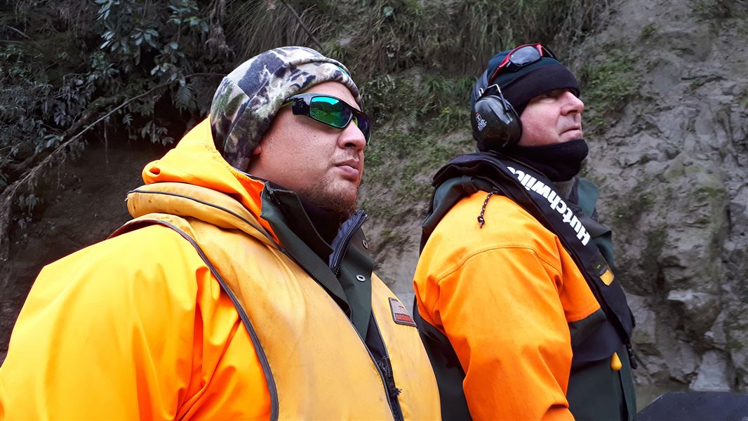 Two people showcasing high visibility clothing as an example of safety clothing.