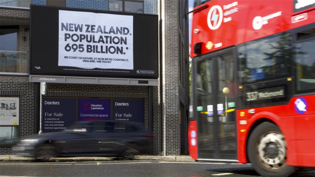 Wandsworth, London with billboard showing New Zealand population 695 billion. 