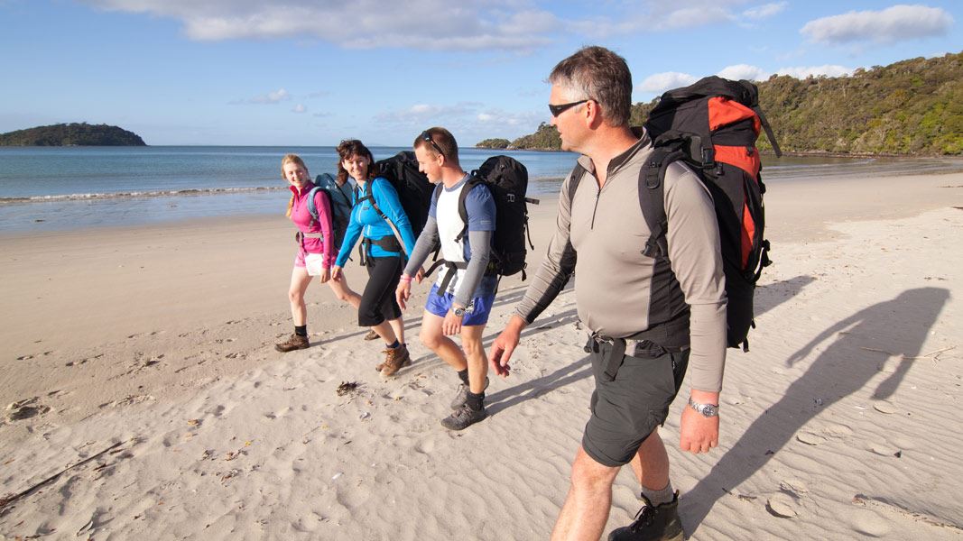 Trampers on beach. 