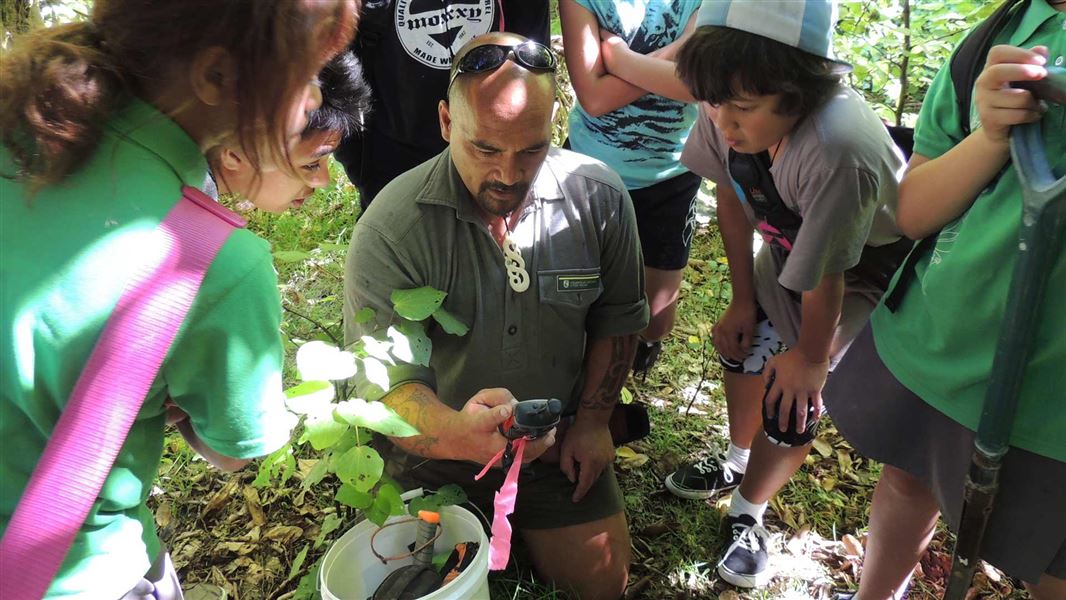 Ranger Joe Waikari shows GPS trapping technology to school students