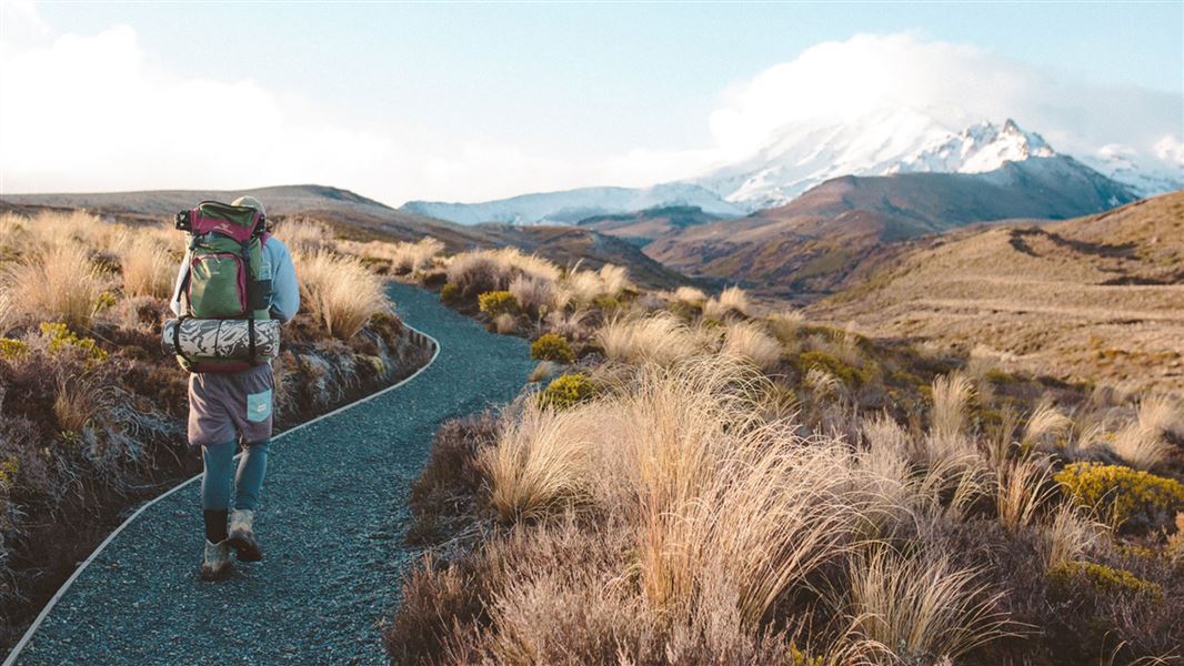 Hiker on Tongariro Northern Circuit with a view of Mount Ruapehu.