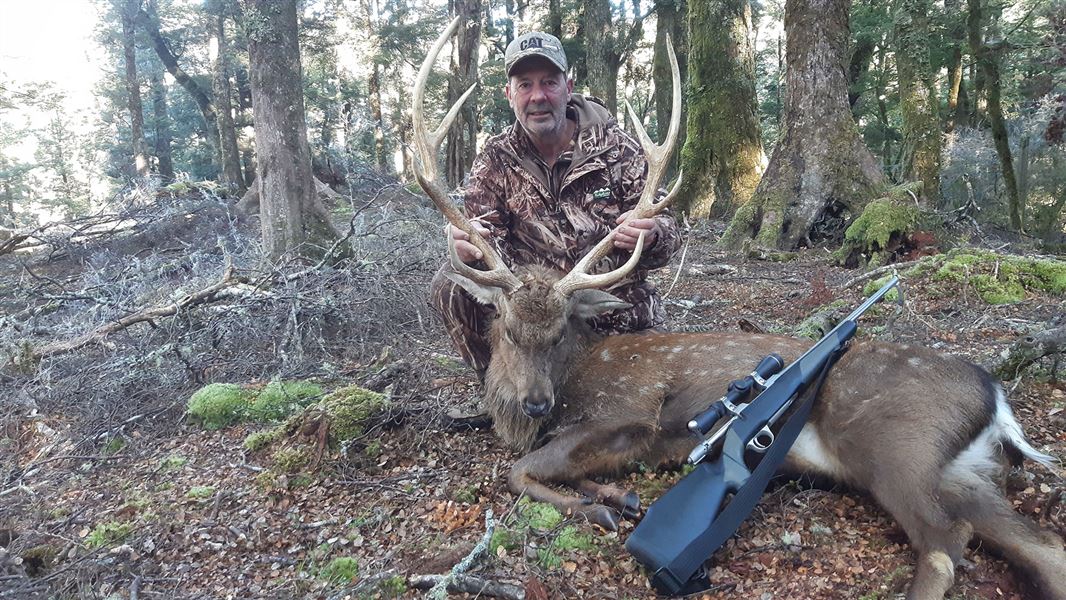 Man with dead deer.