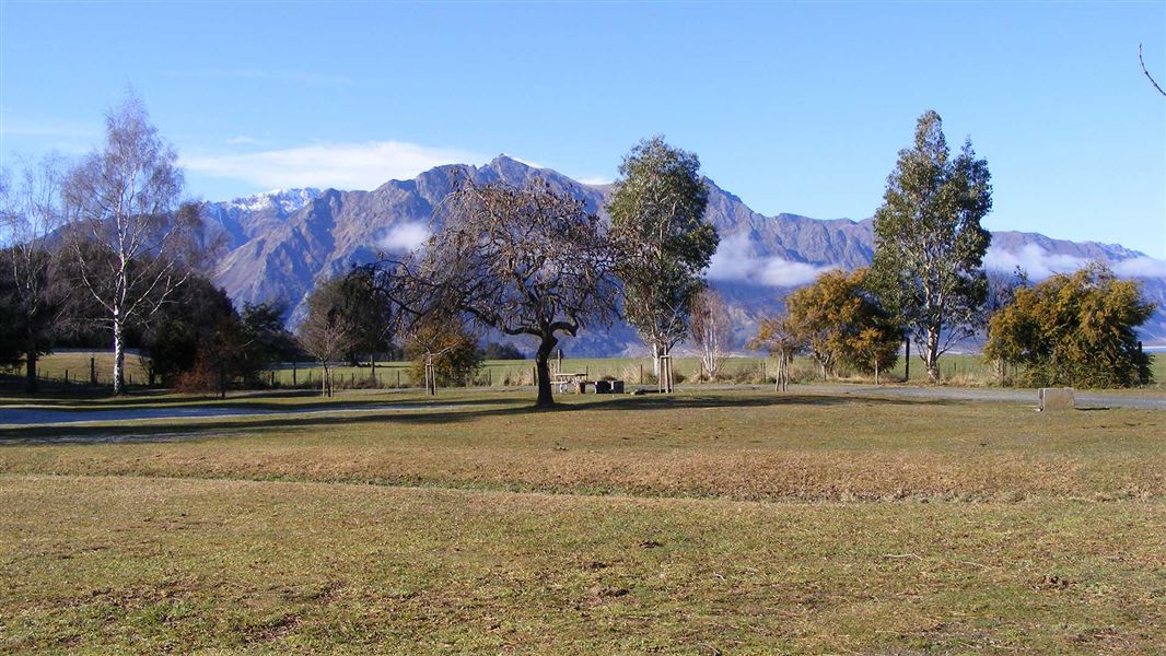 A flat field for camping with mountains in the background.