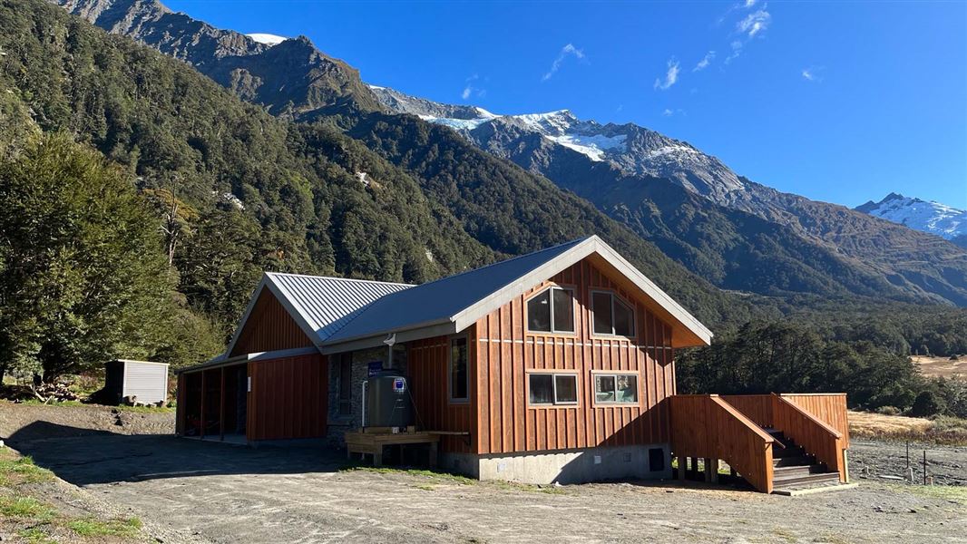 Aspiring Hut in the beautiful Matukituki Valley with snowy mountains in the background.