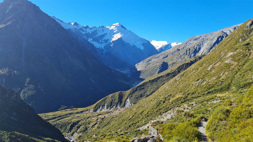 View up valley with tall mountains either side and a snow capped mountain at the end. 