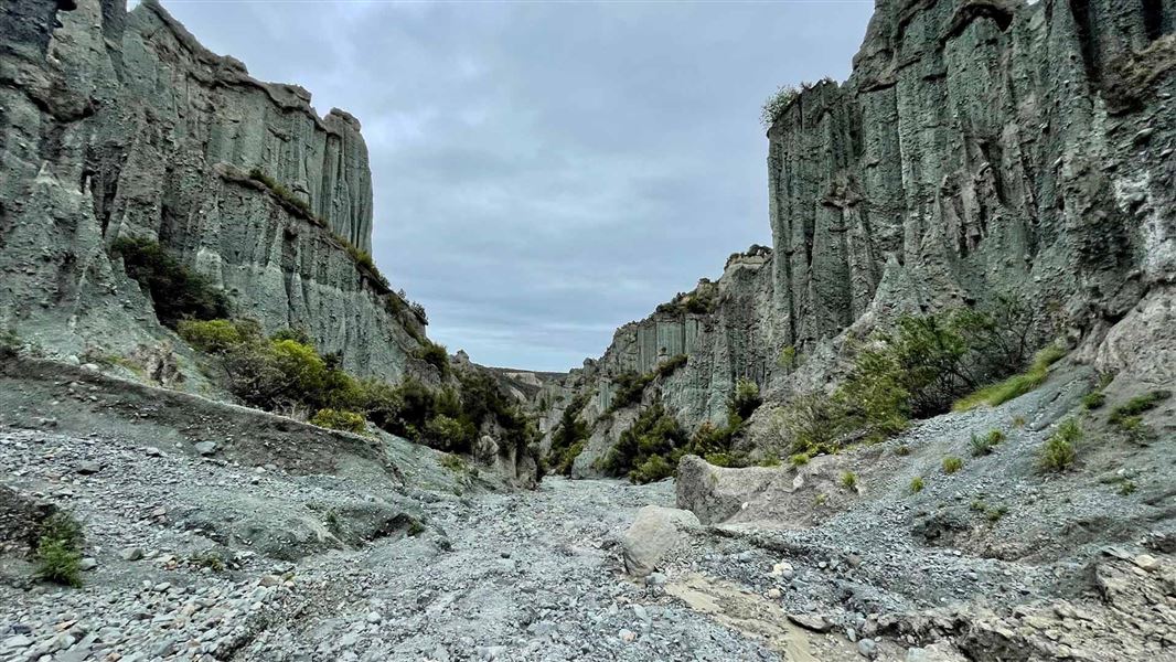 Tall pillar like rock formations with a track leading through the centre.