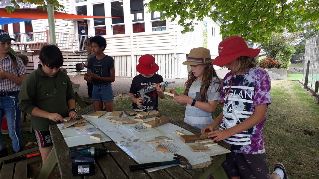 A group of children working with small bits of wood to create a small box.