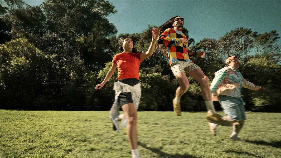 Young people running and jumping on grass. 