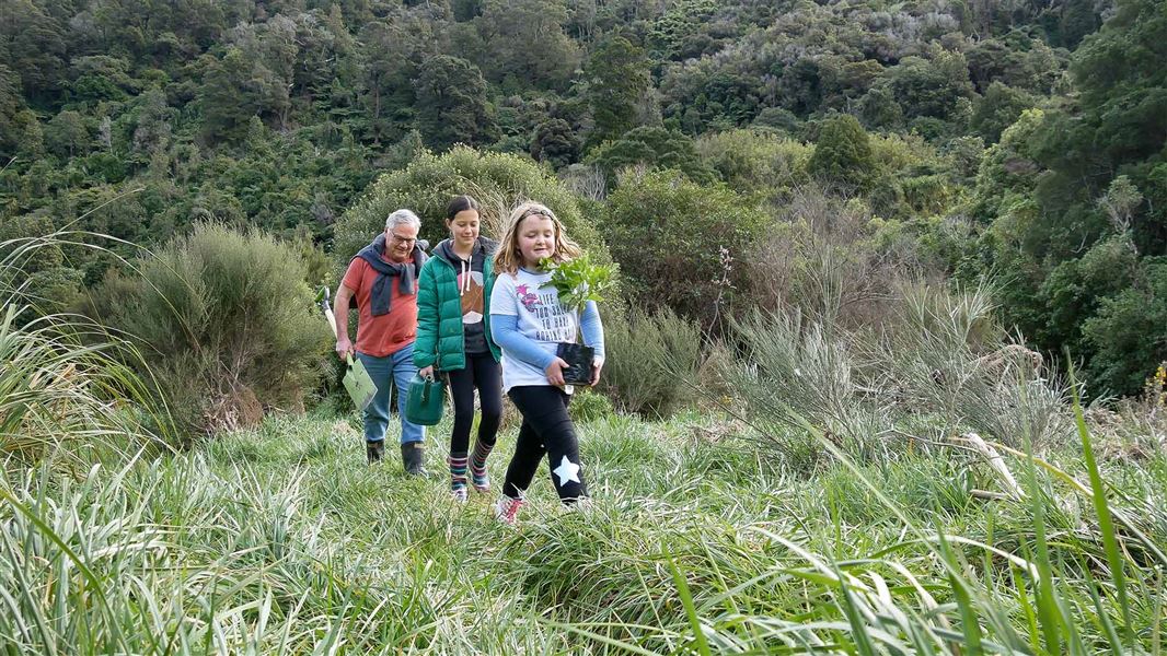 A group of people walk through nature.