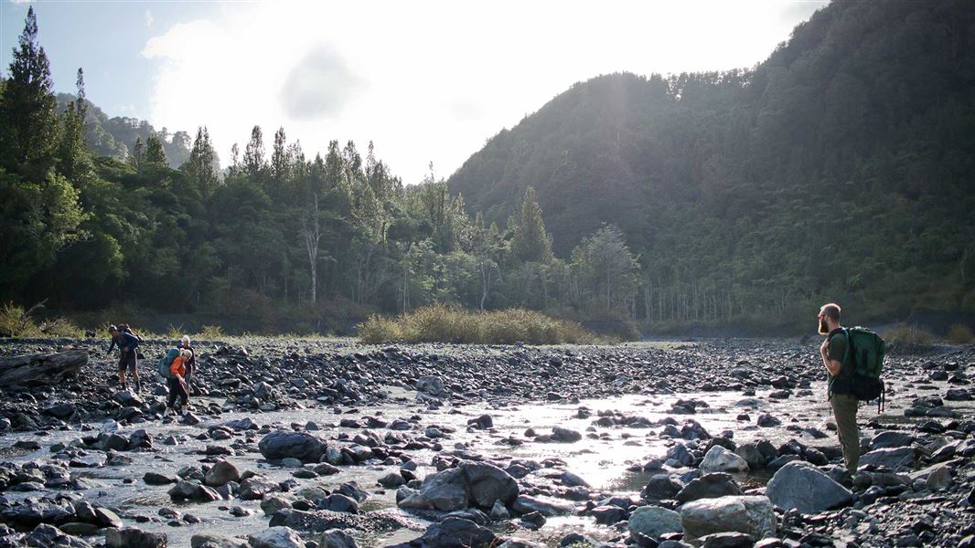 People crossing the Ōrongorongo River.