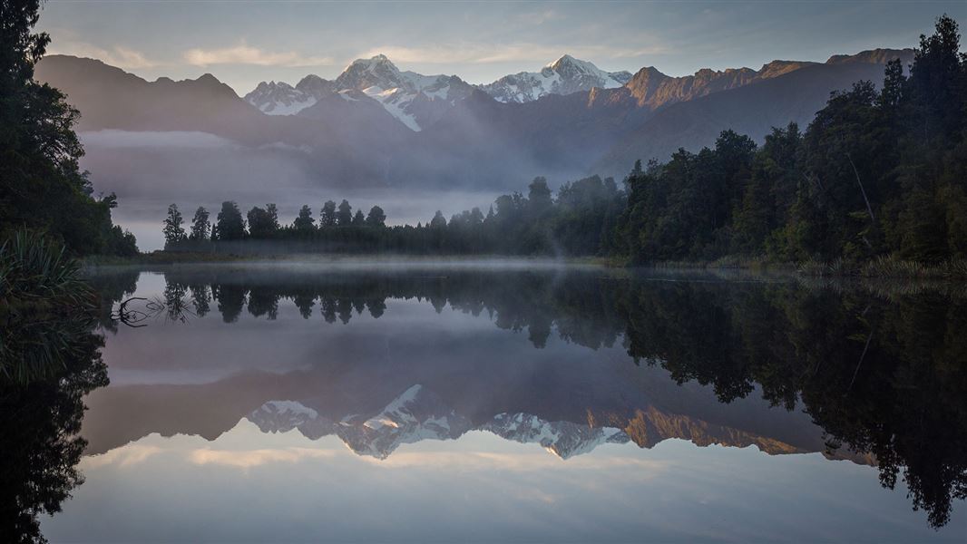 Mountains reflected in the still surface of a lake.